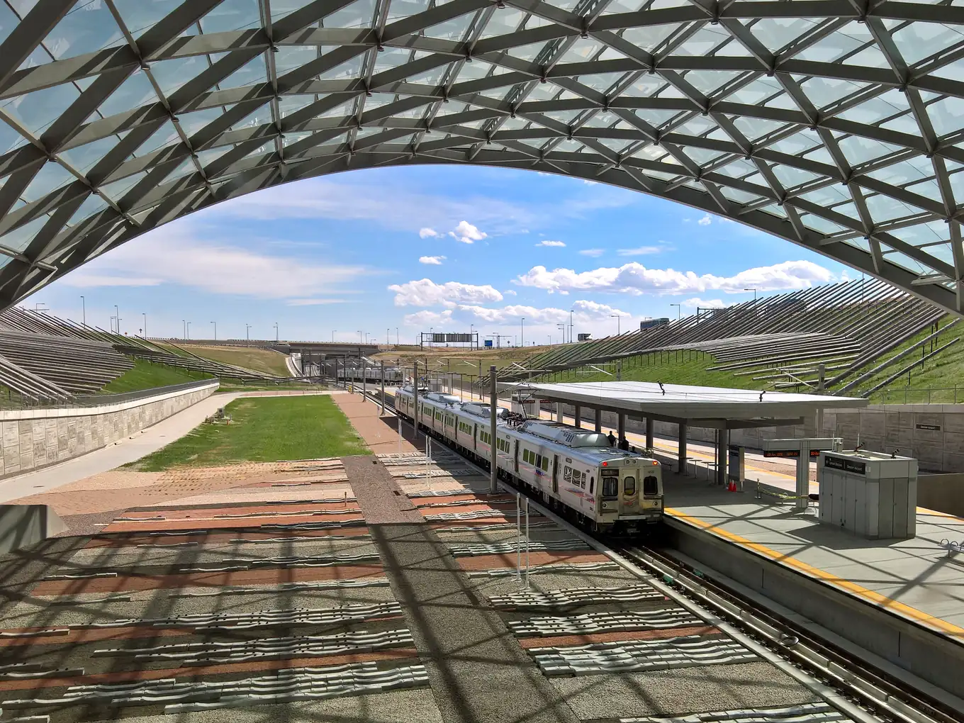 An A Line train at Denver Airport station, under the terminal's tent roof.