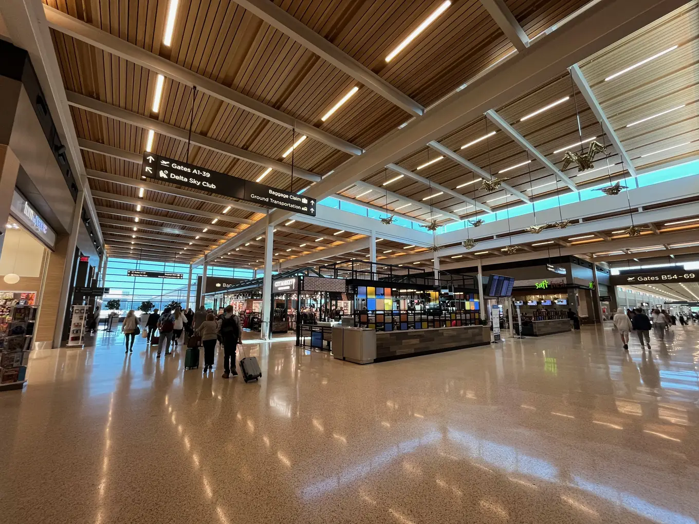 The departures hall of the 2023 terminal at Kansas City International Airport, under its timber ceiling.