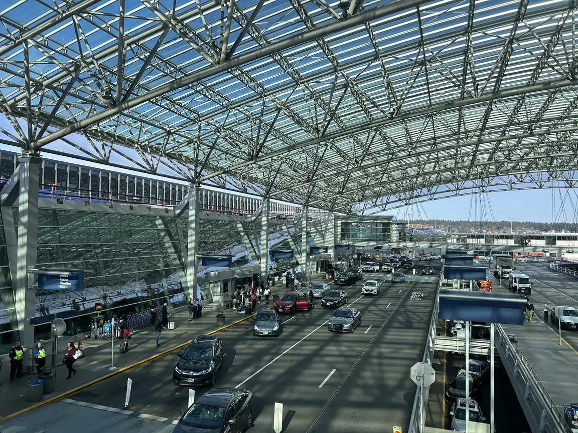The curbside at Portland International, under the glass and timber canopy over the roadway.