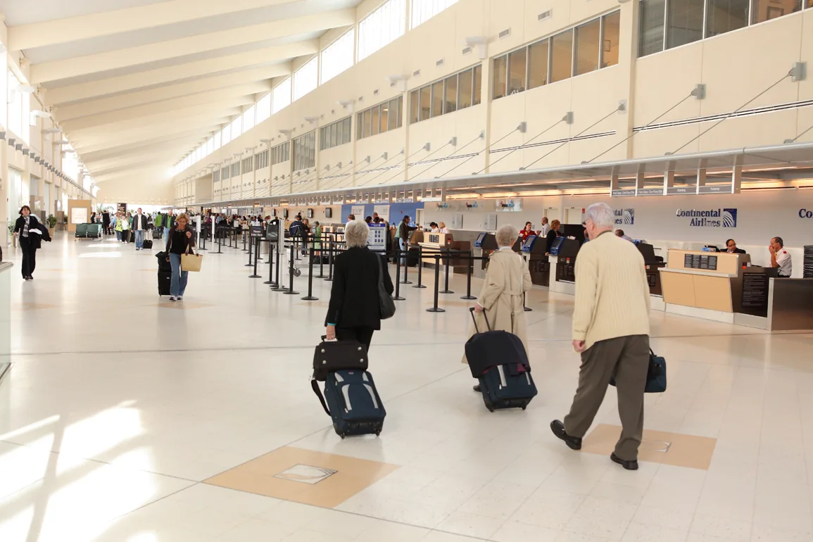The ticketing hall at Southwest Florida International Airport in Fort Myers, with travellers wheeling bags toward the counters.
