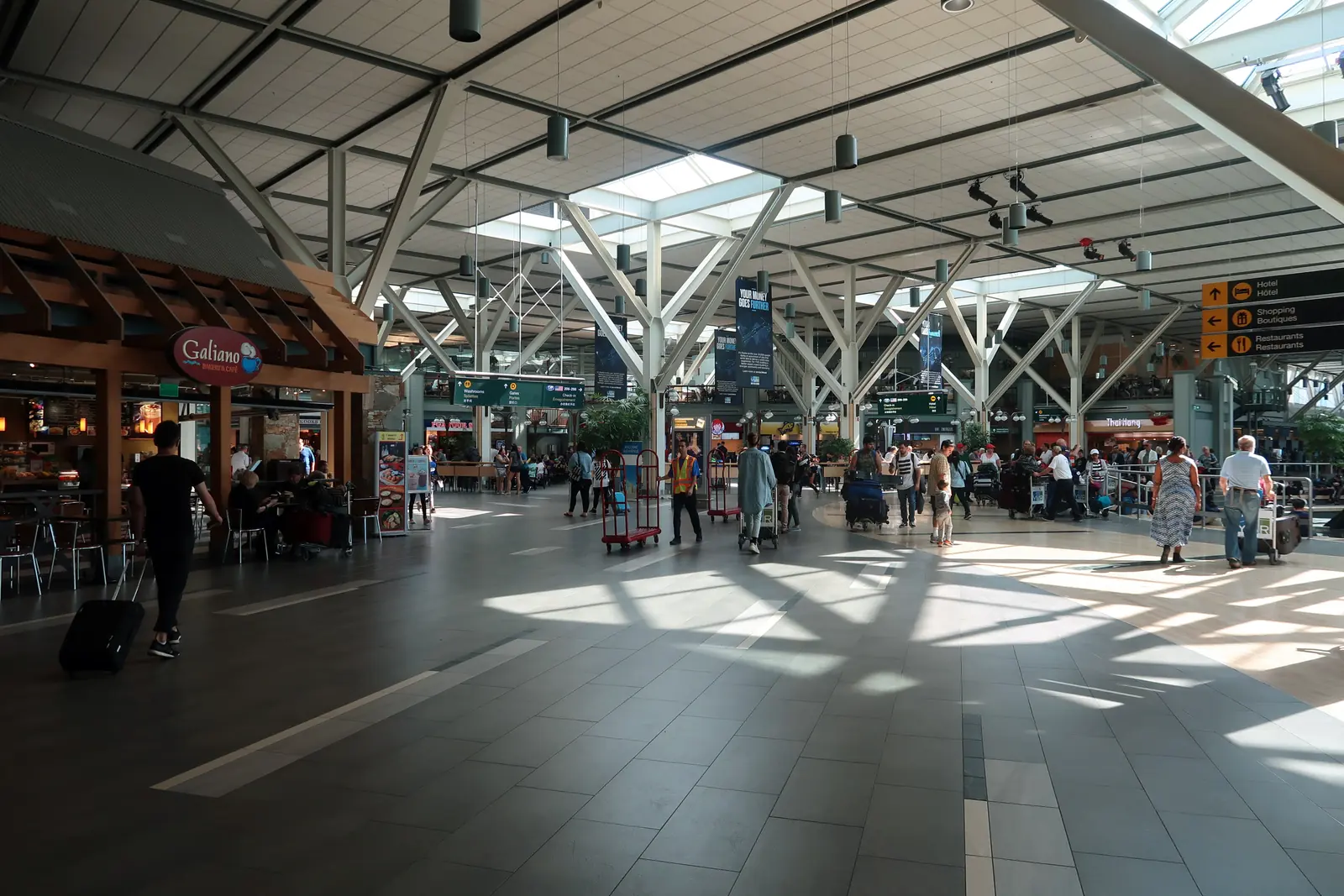 The international departures concourse at Vancouver International, under its trussed roof.