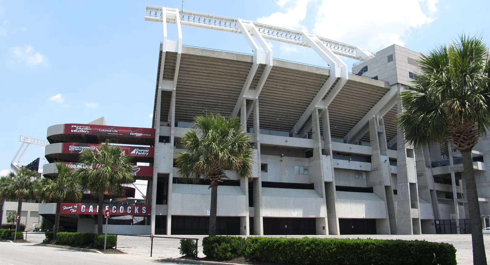 Williams-Brice Stadium in Columbia, South Carolina, seen from the street with palmettos in front.