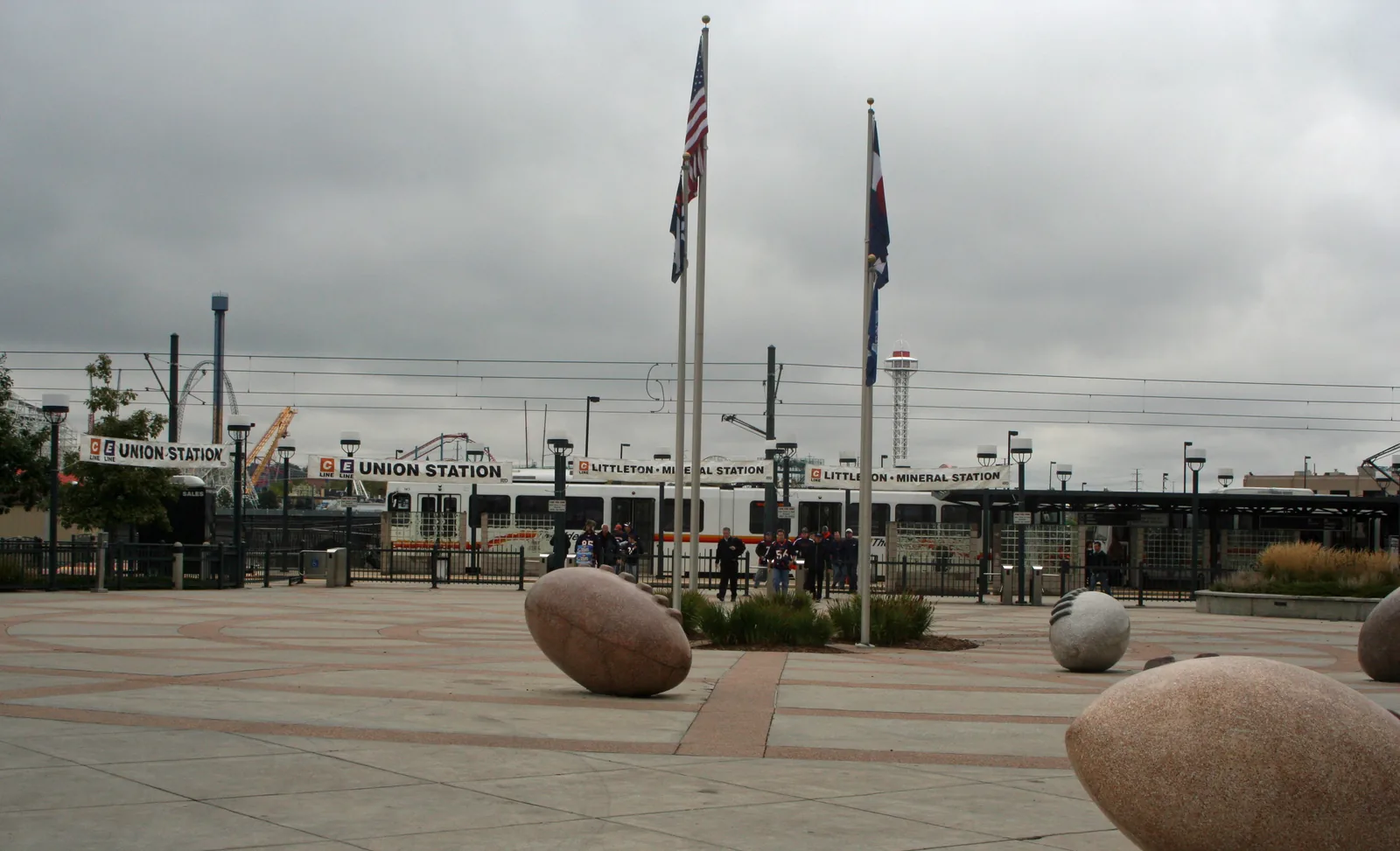 The RTD light rail platform at Empower Field at Mile High station, with the stadium lots behind it.