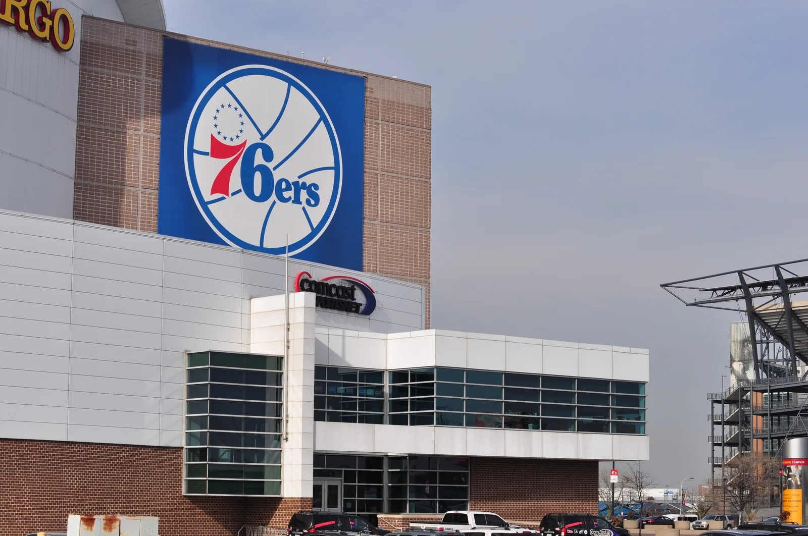The arena in the South Philadelphia sports complex, seen from the street with the 76ers mural on its side.