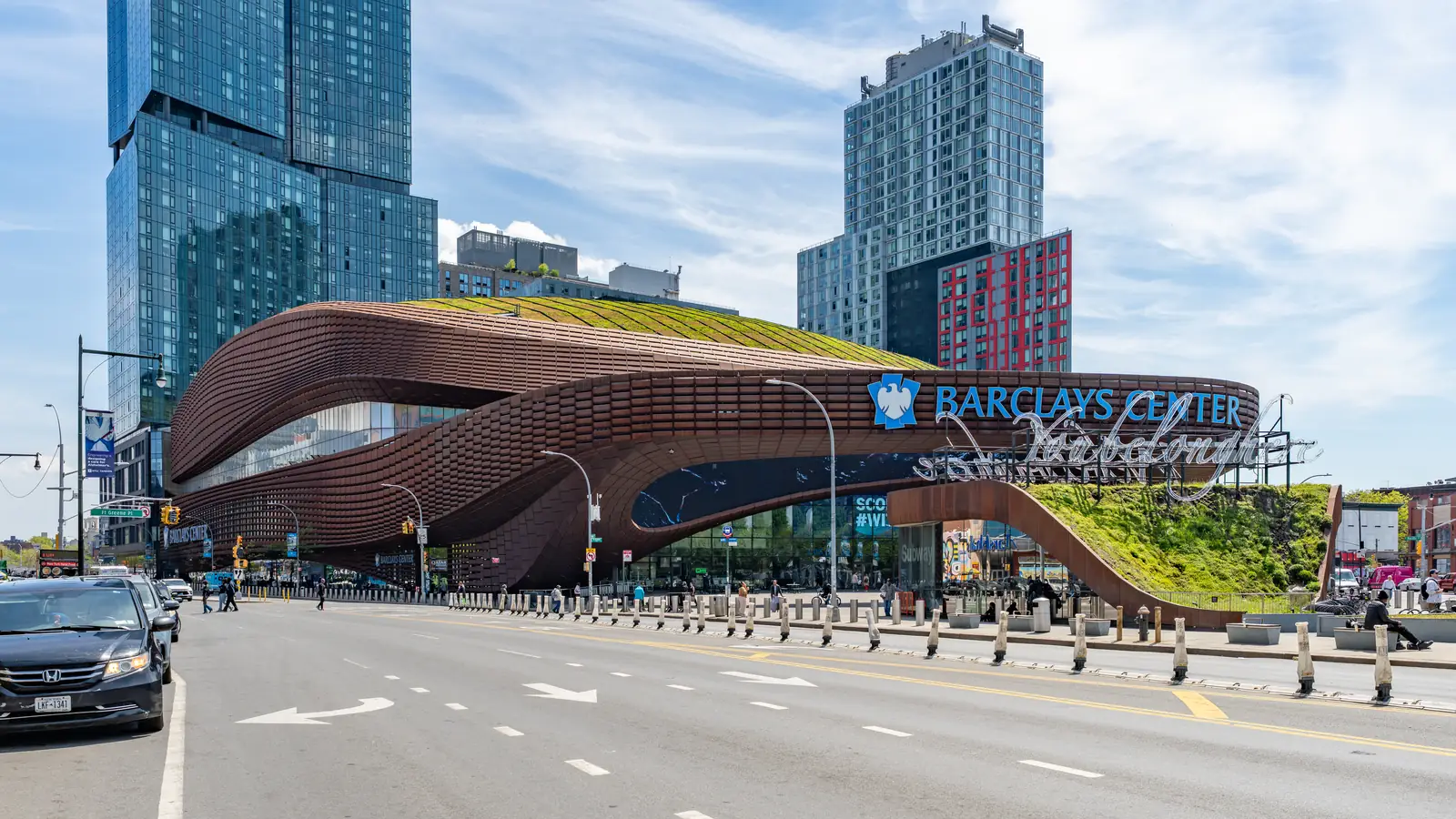 Barclays Center from the corner of Atlantic and Flatbush, the rusted steel canopy curving over the entrance plaza.