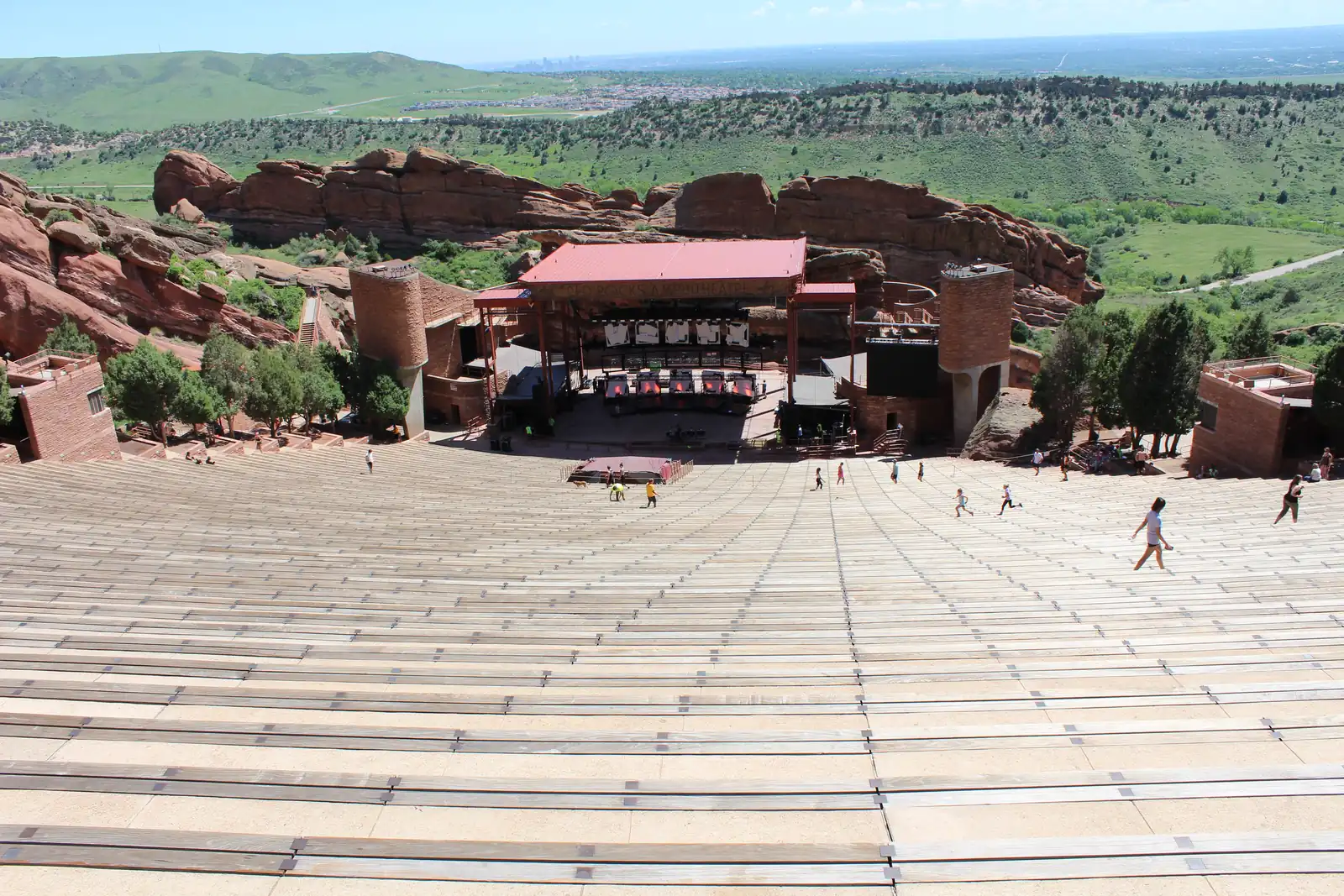 Red Rocks Amphitheatre from the top rows, the benches running down to the stage between the two rock walls.