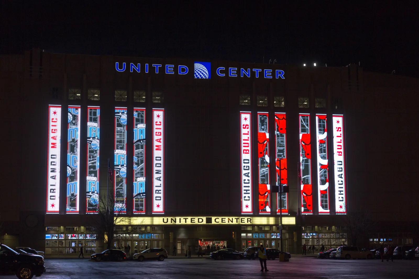 The United Center in Chicago lit at night, its marquee and event banners above the entrance.